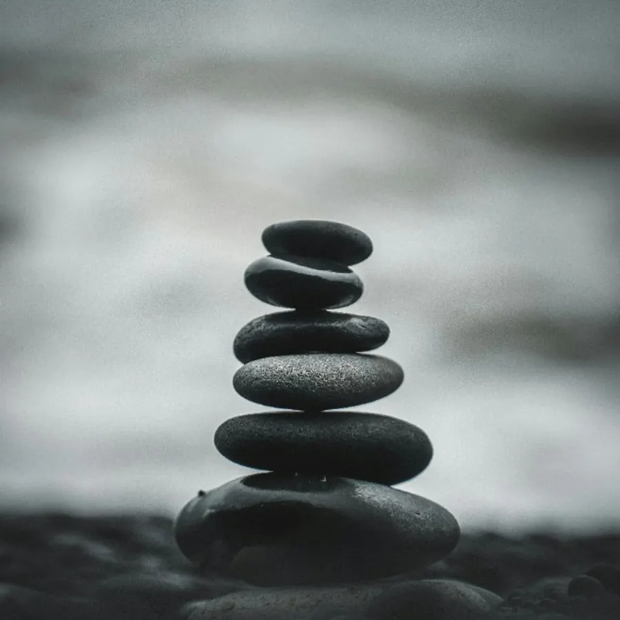 Balanced stones by the water — a symbol of restoring equilibrium Balanced stones by the water — a symbol of restoring equilibrium