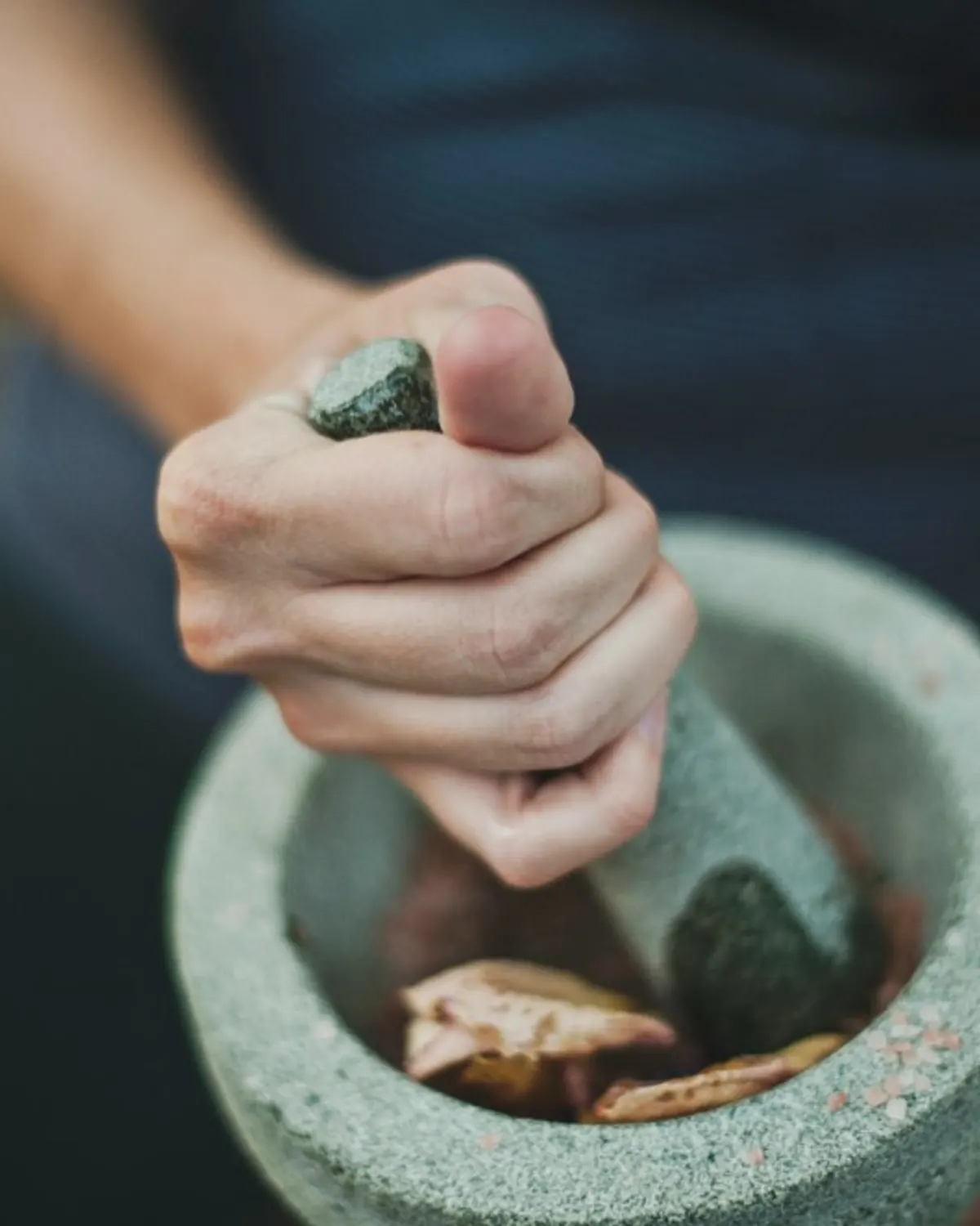 Grinding herbs with a stone mortar and pestle
